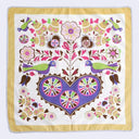 Colorful patterned fabric with birds, flowers, and a heart design on a white background.
