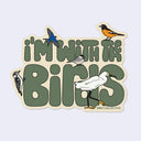 A die-cut sticker featuring the phrase “I'M WITH THE BIRDS” in large olive-green letters, decorated with illustrated birds including a bluebird, oriole, chickadee, woodpecker, egret, and swan. Small text at the bottom reads “BIRD COLLECTIVE.