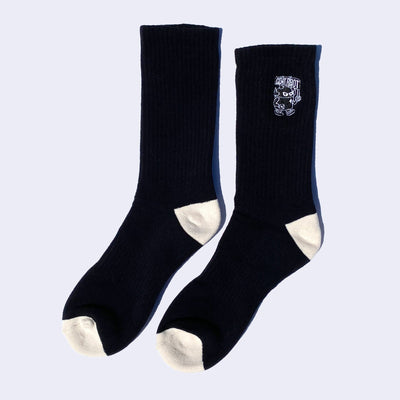 Black mid calf length socks with cream colored toes and heels and a small embroidery on the upper calf part of a robot carrying a flag that reads "Giant Robot." 