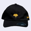 Black cap with a yellow-orange ginkgo leaf in the middle. "Giant Robot" is written in cursive along the side of the cap.