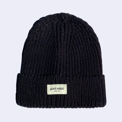 Black knit beanie with a small cream colored rectangle embroidered on the front that reads "Giant Robot" in cursive with "since 1994" below it in all caps.
