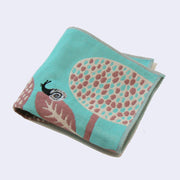 Blue square shaped handkerchief, with a design of a small black and gray snail on rounded flowers - a reddish purple with cream colored accent. Folded.