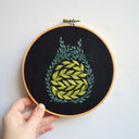 Embroidery hoop with silhouette of Totoro, made up of leaves and vines.