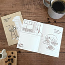 Two illustrated cards on a wooden table with a cup of coffee and coffee beans.