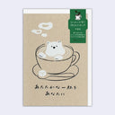 Kraft brown greeting card with japanese text and an illustration of a cup of coffee with a saucer, spoon, sugar cube and bear made out of foam within the latte.