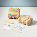 Children's craft kit with biodegradable bee mold, colored pencils, and printed materials on a light surface.