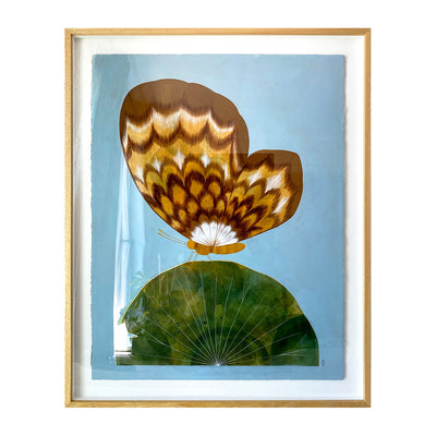 Collage style painting on solid blue paper of a large brown and white moth, visible in profile view with only 1 wing showing. It stands atop of a large half circle made to look like a green lily pad. Piece is in a thin, light grain wooden frame.