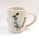 White mug with a black and blue bird design on a white background