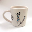 White mug with black and blue bird design on a white background