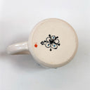 Ceramic mug with decorative design on a white background