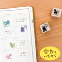 Calendar with cat-themed stamps on a wooden surface