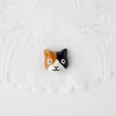 3D ceramic brooch/pin of a calico cat's head, with a simple and cute cartoon smile.