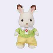 Toy rabbit figure with flocked fur, wearing a green shirt with white polka dots and yellow shorts on a light purple background