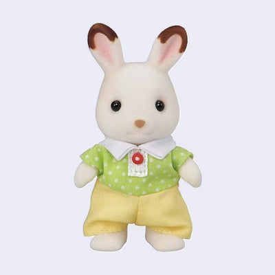 Toy rabbit figure with flocked fur, wearing a green shirt with white polka dots and yellow shorts on a light purple background