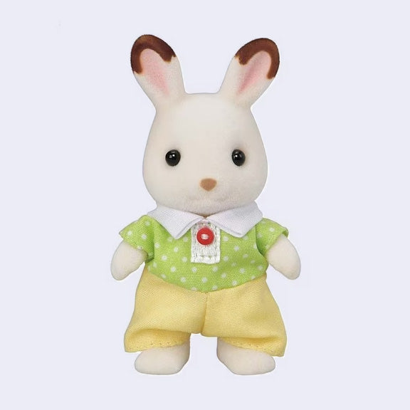 Toy rabbit figure with flocked fur, wearing a green shirt with white polka dots and yellow shorts on a light purple background