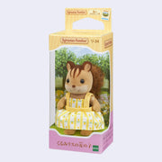 Small figurine of a squirrel, with flocked fur and a fluffy fabric tail. It wears a yellow dress with flowers on it. In its packaging box.
