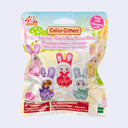 A package of Colico Critters figures in a plastic bag with a colorful printed packaging, showing several small bunny-like characters in pink, purple, red, and green outfits, with text including 'Calico Critters' and 'Collect all 5!'.