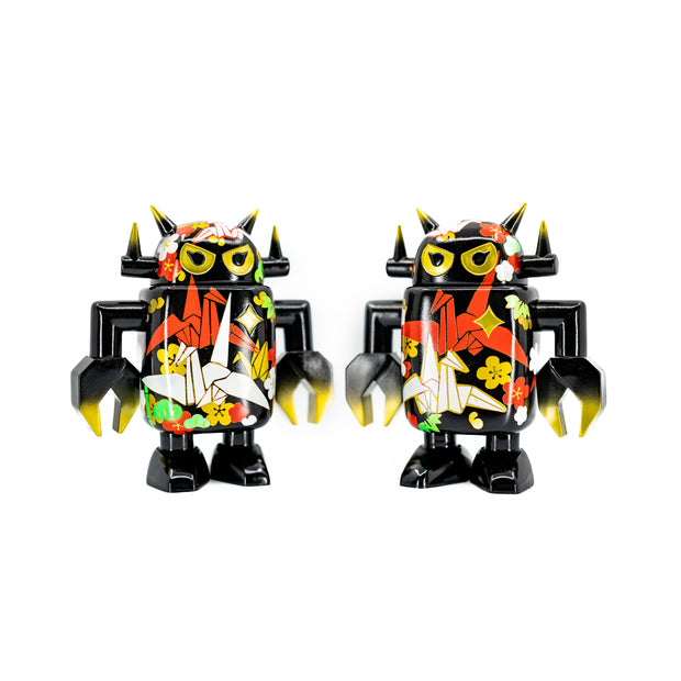 Black spray painted Big Boss Robot figures, with gold, white, red and green color accents. Their robot body features designs of paper cranes, as well as small leaf and flower iconography.