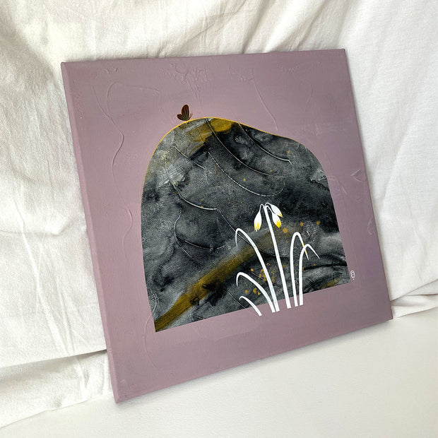 Collage style painting on solid mauve colored canvas of a rock with grey marble patterning and gold streaks. A small black butterfly sits atop the rock with blades of white grass in the lower right. Displayed at an angle.