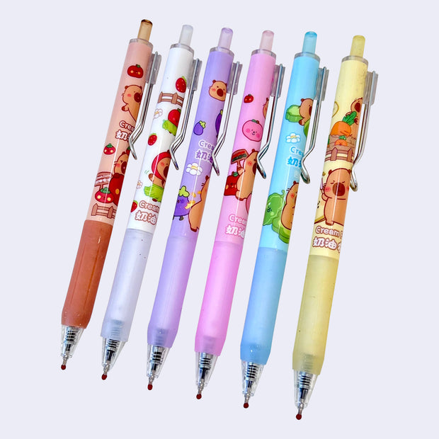 Set of colorful pens with cartoon capybara designs with fruit themes.