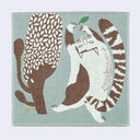 Teal blue square handkerchief towel with an illustration of a white cat with brown stripes and spots, playing with a floating green leaf. It is next to a stylized tree, the same size as itself.
