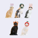 Set of cat figurines wearing various hats on a white background