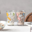 Two glasses with animal illustrations on a table.