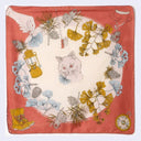 Decorative scarf with a cat, lantern, and floral design on a red background