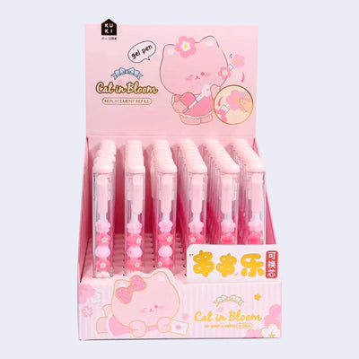 Display case of 48 pink pens with clear bodies that show sakura flowers inside and small cat heads.