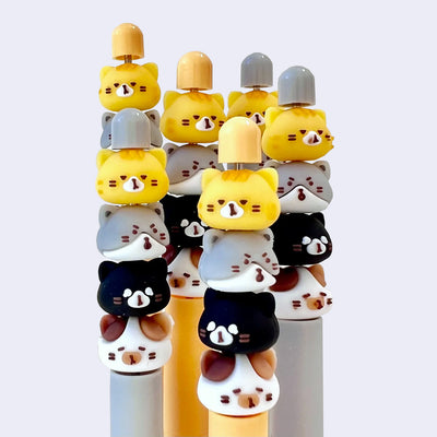 Stack of colorful cat-shaped pens on a white background