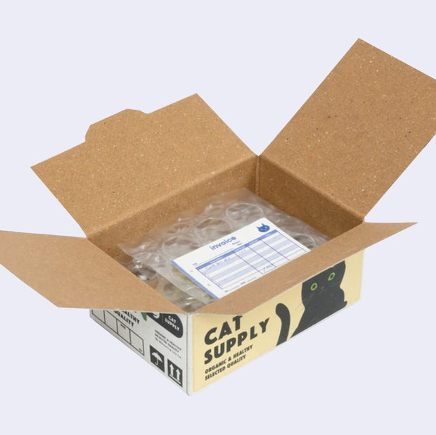 Open box of miniature stickers, made to resemble a shipping box with bubble wrap around the product and a small invoice. Exterior of box looks like realistic cat pet supply box.