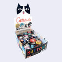 Box of buttons with a cat-themed packaging design on a white background