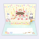 A 3D pop-up greeting card featuring cute illustrated cats around a strawberry birthday cake with candles. The card is shown open, revealing a pastel background with bunting, confetti, and a mint-green striped base.
