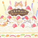 A Japanese birthday pop-up cake card featuring cute illustrated cats on a strawberry cream cake with candles and Japanese text on a sign.
