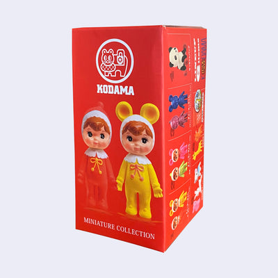 Red blind box packaging for Charmy Chan miniature collection blind box, with 2 Charmy Chans on the front dressed in red pajamas and in yellow, with mouse ears. The side of the box shows some options. 