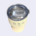 Yellow tumbler with clear lid on a light purple background