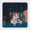 A rounded edge square sticker of an orange and white cat wearing blue gaming headphones and holding a white game controller, with a dark blue background and a light gray border around the sticker.