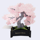 3D greeting card of a Japanese cherry blossom tree with pink flowers on a light blue background.