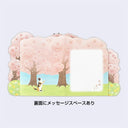 Back view of card, with an illustration of 3 cherry blossom trees and a calico cat on its hind legs looking at the falling blossoms. Next to the cat is a blank writing area.