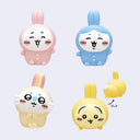 Set of four colorful rabbit-shaped figurines on a light purple background