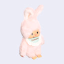 Pink plush toy with a white bib on a light gray background