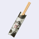 A pair of light wood chopsticks resting inside a decorative paper chopstick sleeve with a black, white, and red samurai design, set against a light gray background.