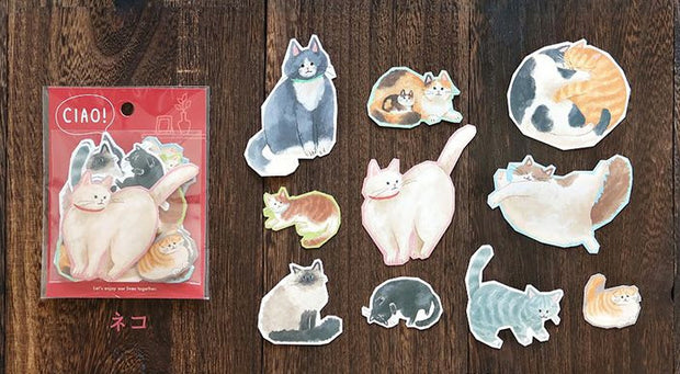 Set of cat-themed stickers on a wooden surface with a red packaging labeled 'CIAO!'.