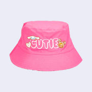 Hot pink bucket hat, featuring white bubble letters that read "CUTIE." Cinnamoroll is on one side and Donutella is on the other.
