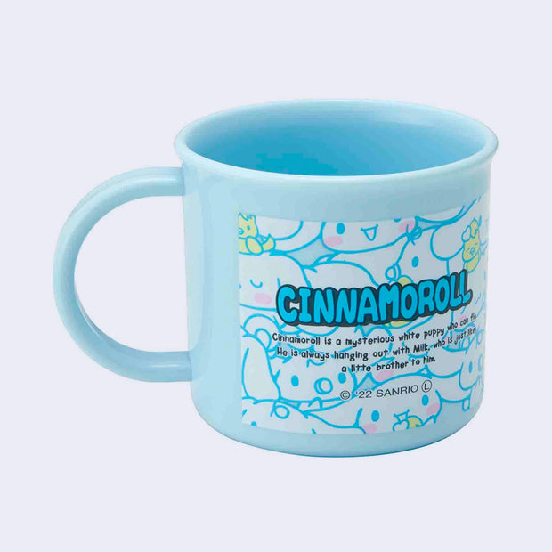Small blue plastic cup with a mug handle featuring a text blurb about Cinnamoroll, describing the character's personality.