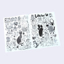 Open 2 page book spread of black and white cat-themed illustrations on a light purple background