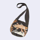 Dark gray sling, shoulder bag with an orange and white graphic of a coelacanth fish swimming over rocks and near coral.