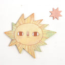 Sun-shaped object with facial features on a white background