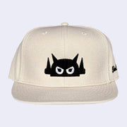 Beige cap with a black and white graphic design on a light gray background