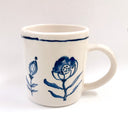 White mug with blue floral design on a white background